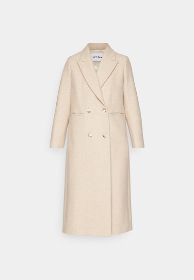 Beige ullblandad kappa med dubbelknäppt design, slagkrage och två framfickor. Har stora knappar och en mjuk textur.
