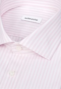 Chemise rayée rose clair et blanche avec col pointu et boutons blancs, affichant l'étiquette de marque « seidensticker » à l'intérieur du col.