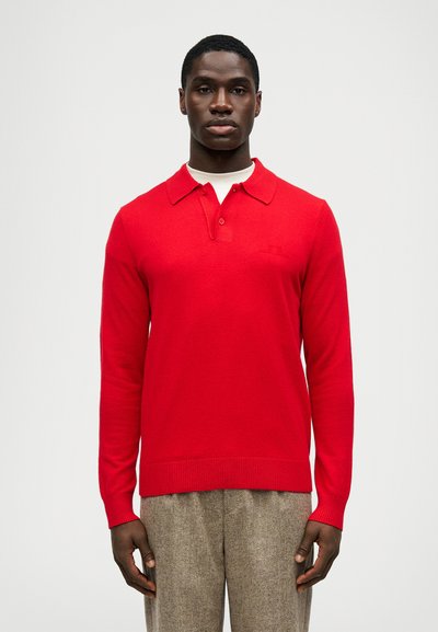Rode polo shirt met lange mouwen en kraag, voorzien van twee knopen en een geborduurd logo op de borst. Soepele textuur en een aansluitend ontwerp.