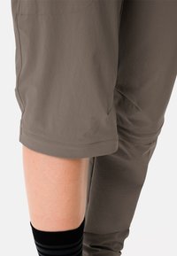 Pantaloni capri marroni leggeri realizzati in un tessuto liscio con una vestibilità dritta, dotati di un orlo risvoltato e di un dettaglio con tasca laterale.