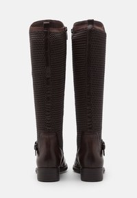 Brązowe skórzane kozaki za kolano z siateczkowym panelem, gładką fakturą, bocznymi suwakami oraz małym akcentem w postaci klamry blisko pięty.