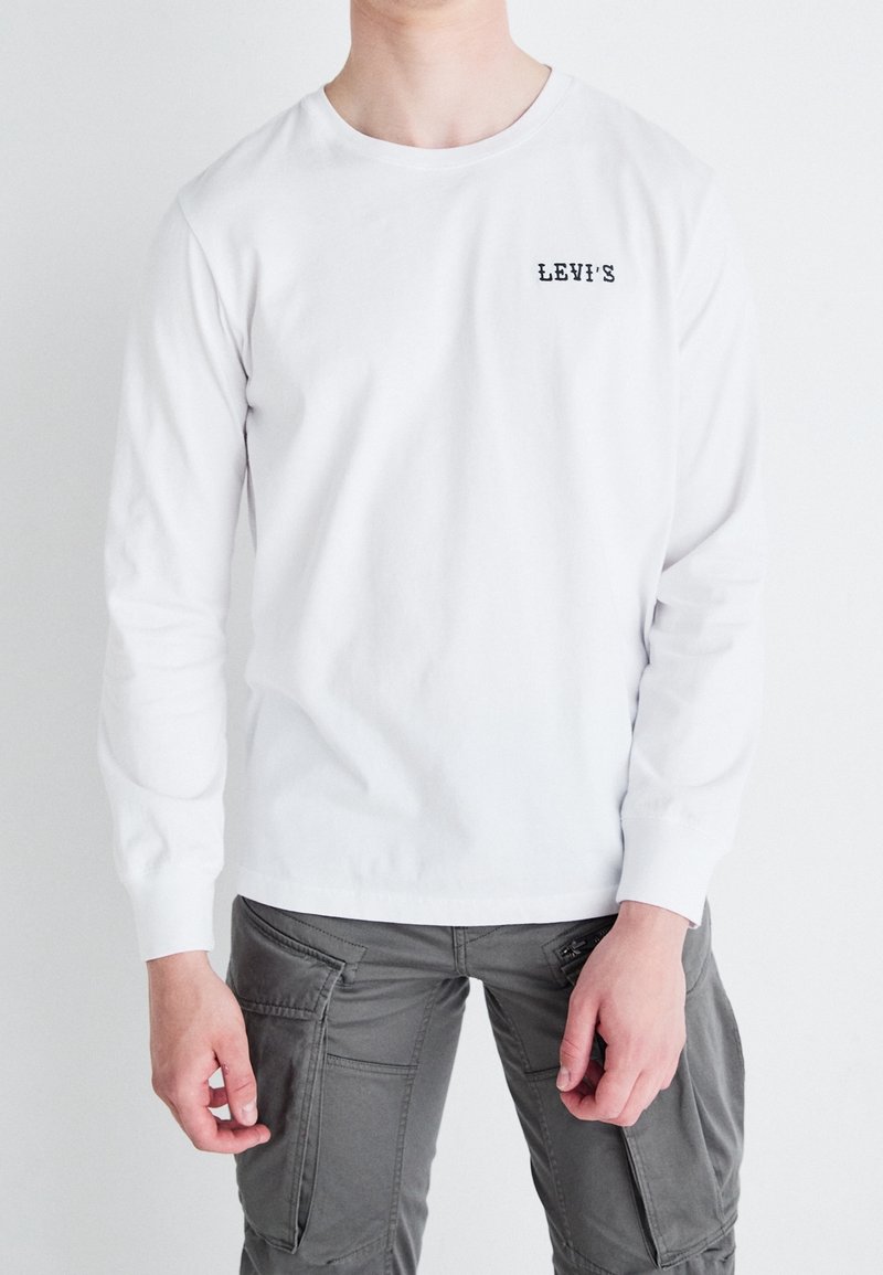 Weißes Langarm-T-Shirt mit Rundhalsausschnitt und kleinem schwarzen "LEV'S"-Logo auf der linken Brust, aus Baumwollstoff gefertigt.