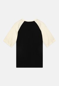 Schwarz-creamfarbene Raglan-T-Shirt mit kurzen Ärmeln, rundem Ausschnitt und glatter, weicher Textur. Keine Grafiken oder Muster vorhanden.