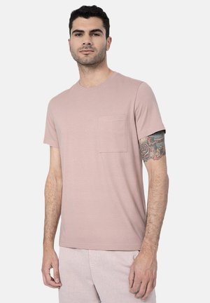 Jasnoróżowy t-shirt z krótkim rękawem, okrągłym dekoltem i kieszenią na piersi. Wykonany z miękkiego materiału, o luźnym kroju i minimalistycznym designie.