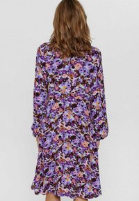 Rochie florală violetă cu mâneci lungi, tiv ușor evazat și un amestec de modele florale vibrante în nuanțe de roz, portocaliu și maro.