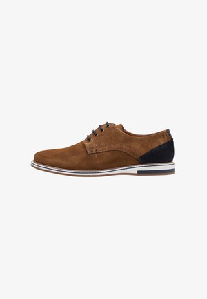 Chaussure habillée pour homme en daim marron à lacets, avec un patch noir au talon et une semelle en caoutchouc blanche ornée d'une bande bleu marine.