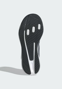 Suola di scarpa nera in gomma con un motivo testurizzato, dettagli bianchi e numerosi punti di trazione circolari. Bordo liscio e design robusto.