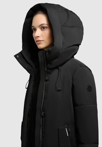 Black puffer jacket with a large hood, front zipper, side pockets, and textured details. Features a logo on the hood and black accents.