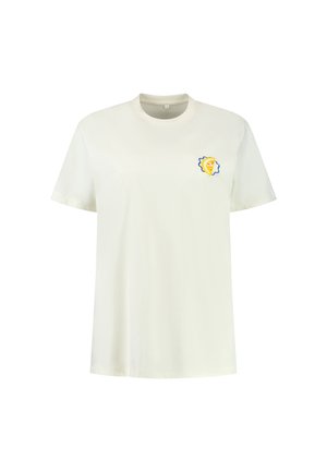 Bela bomba majica s kratkimi rokavi, ki na levem prsnem delu vsebuje majhno grafiko leva v rumeni in modri barvi.