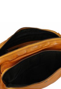 Bolso de cuero naranja con dos compartimentos con cremallera, forro de tela negra y costuras en contraste. Textura suave con un brillo sutil.