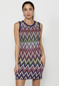 Rochie tricotată fără mâneci, cu un model zigzag în nuanțe de violet, verde, corai și alb. Material texturat cu decolteu rotund.
