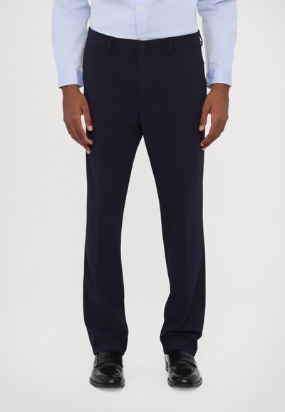 Pantalones de vestir azul marino con corte recto, hechos de una tela suave, con un frente plano, pasadores para cinturón y una cinturilla clásica. Zapatos negros visibles.