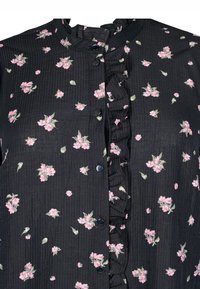 Blusa nera in tessuto rigato con un motivo floreale di fiori rosa, davanti a volant e bottoni neri.
