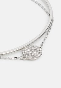 Sølvarmbånd med et slankt, avrundet design med kjedeledd, prydet med en sirkulær medaljong dekket av klare rhinestones.