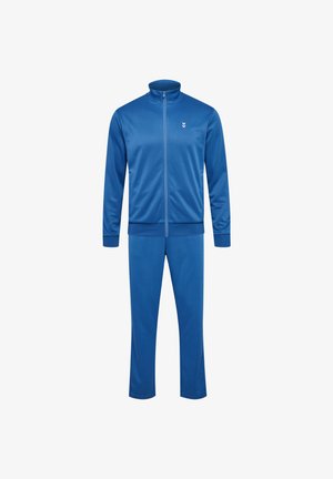 Trainingsanzug aus einfarbigem blauen Stoff mit vollem Reißverschluss, hohem Kragen und elastischen Bündchen. Mit einem kleinen weißen Logo auf der Jacke.