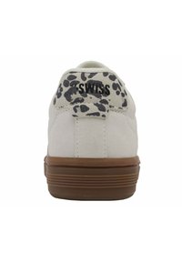 Baskets en suède blanc avec un accent en imprimé léopard texturé sur le talon, dotées d'une semelle en caoutchouc marron et de détails de couture renforcée.