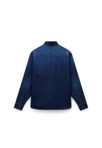 Camisa de denim azul oscuro con mangas largas, puños abotonados y un cuello clásico. Textura suave con un ligero desvanecimiento y detalles de costura.