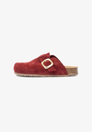 Sabot en daim rouge avec une accent en boucle dorée, semelle en liège et dessus texturé. Design plat avec un bout arrondi et une finition lisse.