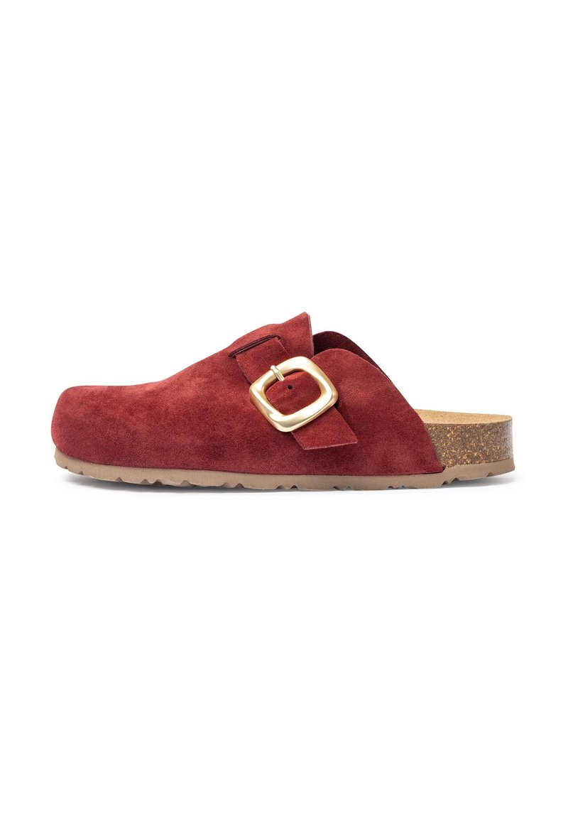 Sabot en daim rouge avec une accent en boucle dorée, semelle en liège et dessus texturé. Design plat avec un bout arrondi et une finition lisse.