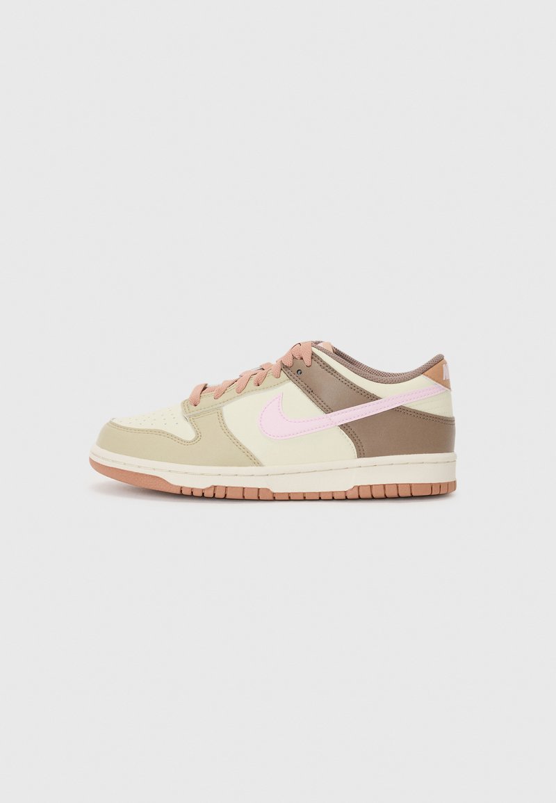 Nike sneakers featuring a cream upper with brown accents, pink logo, textured panels, and a rubber sole with a light brown outsole.