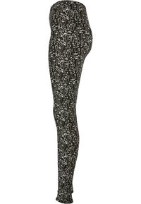 Leggings neri con un motivo astratto bianco, caratterizzati da una vestibilità elasticizzata e polsini alla caviglia, adatti per un abbigliamento casual o per l'esercizio.