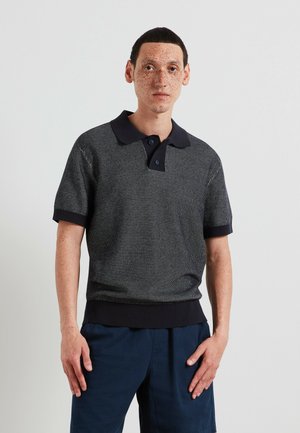 Kurzärmeliges Polohemd in Dunkelblau mit strukturiertem Muster, einem einfarbigen marineblauen Kragen sowie gerippten Bündchen und Saum. Knopfdetail am Ausschnitt.