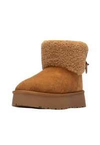 Stivaletti alla caviglia in suede color sabbia con un morbido risvolto in shearling color sabbia, suola in gomma piatta e dettagli con zip laterale per una facile vestibilità. Superficie strutturata, punta rotonda.