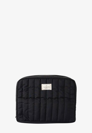 Pochette rectangulaire noire matelassée avec un zip, couture verticale et une petite étiquette de marque blanche centrée près du sommet.