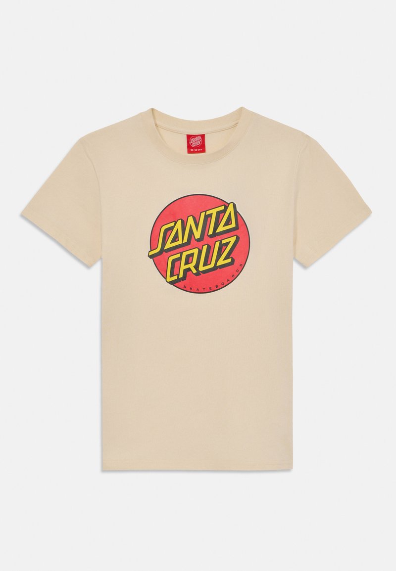 Bežas kokvilnas T-krekls ar centrālu sarkanu apļa grafiku, kurā ir teksts "SANTA CRUZ" resnās dzeltenās burtnēs, gluda tekstūra.