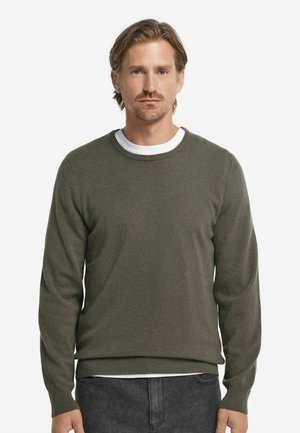 Olive green knit sweater with long sleeves, round neckline, and ribbed cuffs and hem. Layered over a white T-shirt.