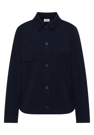 Tmavě modrá texturovaná bunda na knoflíky s límcem, dlouhými rukávy a dvěma předními náprsními kapsami, z nichž jedna má klopu.