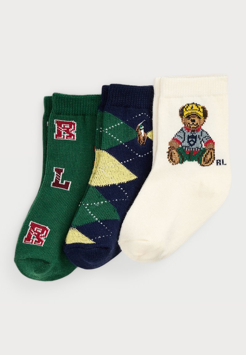 Três pares de meias: verdes com letras vermelhas, azuis com padrão de losangos e logótipo bordado, brancas com um gráfico de urso em uma camiseta.