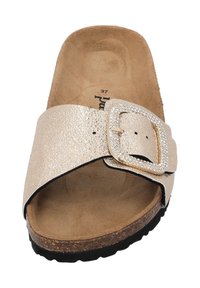 Sandal in oro, texture con una larga fascia, grande fibbia decorata con strass e una soletta imbottita marrone. Suola piatta per il massimo comfort.