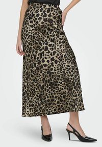 Gonna maxi in satin con stampa leopardata e vita alta, caratterizzata da una texture liscia e un taglio dritto, abbinata a décolleté nere con cinturino sul retro.