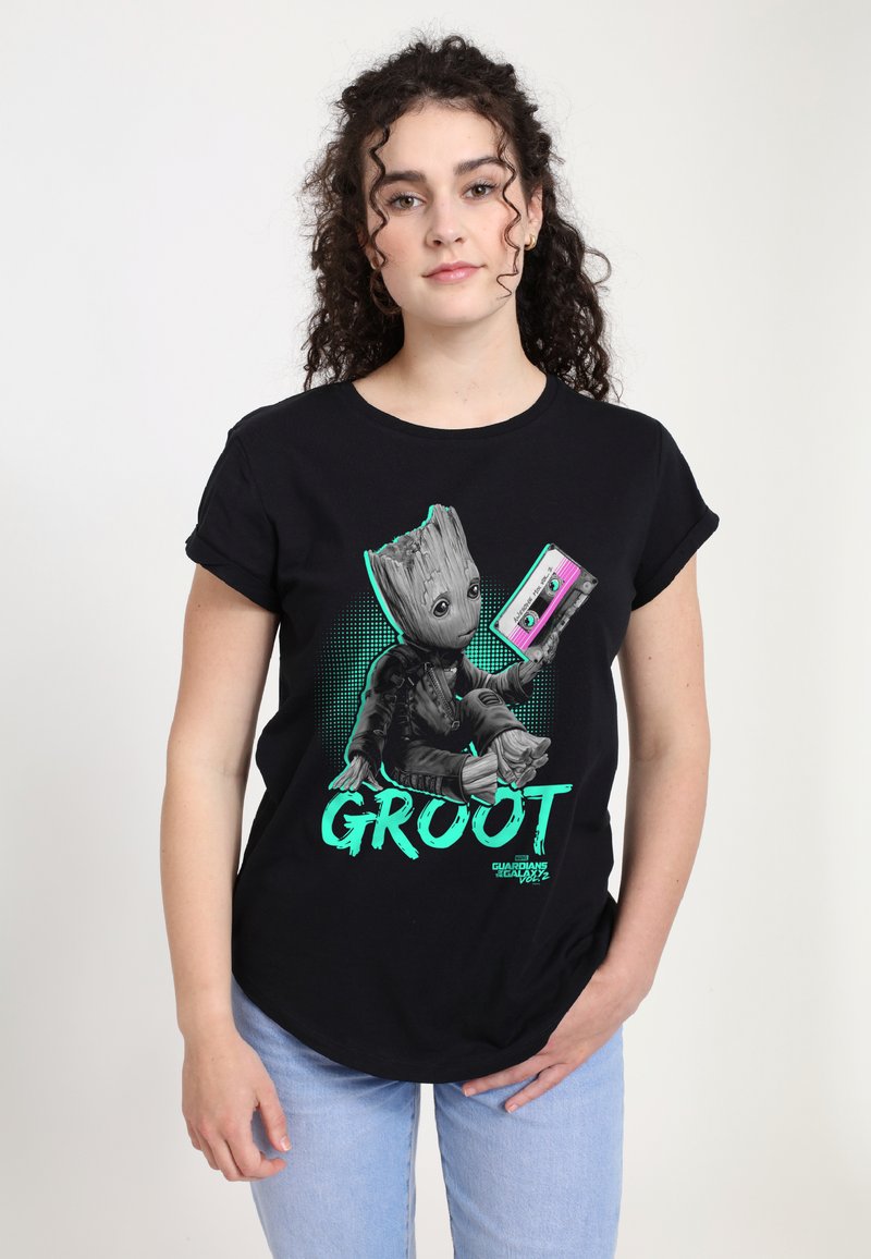 Černé bavlněné tričko s grafikou Groota, s tyrkysovými akcenty, který drží fialovou kazetu, a slovo "GROOT" v tučném písmu.