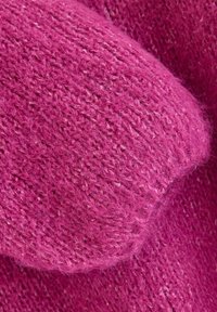 Blødt strikket stof i levende magenta med et tekstureret mønster og bløde, fine fibre, der fremhæver en glat, afrundet form.