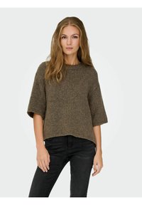 Brown knitted sweater with short sleeves, ribbed texture, and a rounded neckline, paired with black jeans. Simple, relaxed fit design.