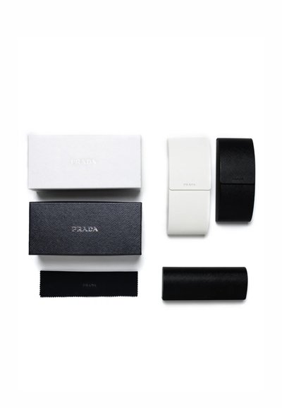 Custodie per occhiali Prada: materiali texturizzati in bianco e nero, forme rettangolari e curve, accompagnate da un panno pulente nero con logo in rilievo.