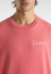 Klassisches T-Shirt aus Baumwolle mit kurzen Ärmeln in Korallenpink, mit einem weißen Vans-Logo auf der linken Brustseite und einem klassischen Rundhalsausschnitt.