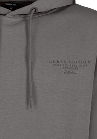 Grau Hoodie aus weichem Stoff, mit einer Kordelzugkapuze und einem bedruckten Design, das "URBAN EDITION ONLY THE REAL ONES SUBLEVEL" lautet.