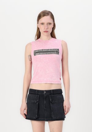 Tettsittende rosa ermeløs topp med en teksturert svart glidelåsdelsdesign over brystet, parret med et svart denimskjørt som har frontlommer.