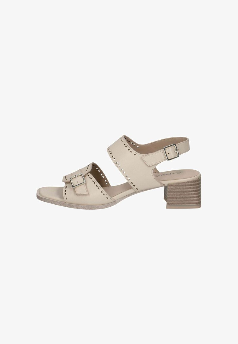 Sandale en cuir beige avec deux larges brides, découpes décoratives, boucle et talon bloc texturé. Semelle plate pour le confort.