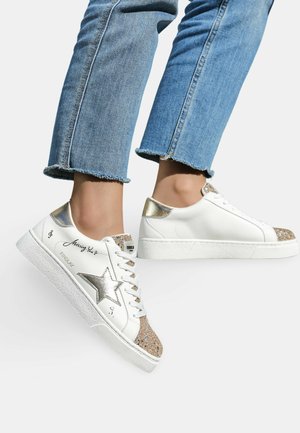 Baskets blanches en cuir avec un accent étoile dorée, un embout beige pailleté et un talon doré métallisé. Présente une semelle texturée blanche et des lacets.