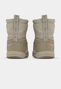 Beige technische sneakers met een gewatteerde kraag, waterafstotend materiaal en logodetails op de lussen en zijpanelen. Rubberen zolen.