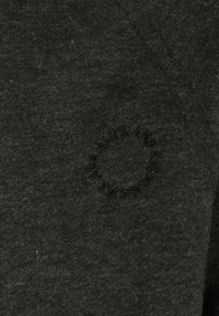 Dark gray pullover with a soft texture. Features a circular embroidered detail on the chest. Material appears to be a knitted fabric.