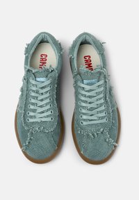 Light teal sneakers featuring a textured fabric upper with frayed edges, flat laces, and a brown rubber sole. Red brand logo inside.