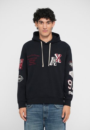 Navy Kapuzenpullover mit Kordelzug, ausgestattet mit gestickten Patches, den Buchstaben "AX" und sportlichen Motiven. Weicher Stoff, lässige Passform, gerippte Bündchen.
