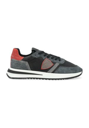 Sneaker da uomo con tomaia in suede nero e grigio, dettagli rossi, patch con logo e suola bianca. Presenta un tessuto testurizzato e un design snello.