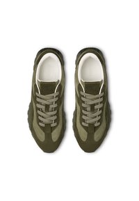 Zapatillas de ante verde con acentos beige, cordones texturizados, suelas gruesas y logo en relieve en la lengüeta, vistas desde arriba.