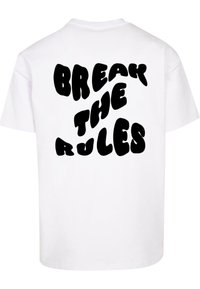 Hvid bomulds t-shirt med en dristig sort grafisk tekst på ryggen, der står "BRYT REGELNE" i en buet skrifttype.